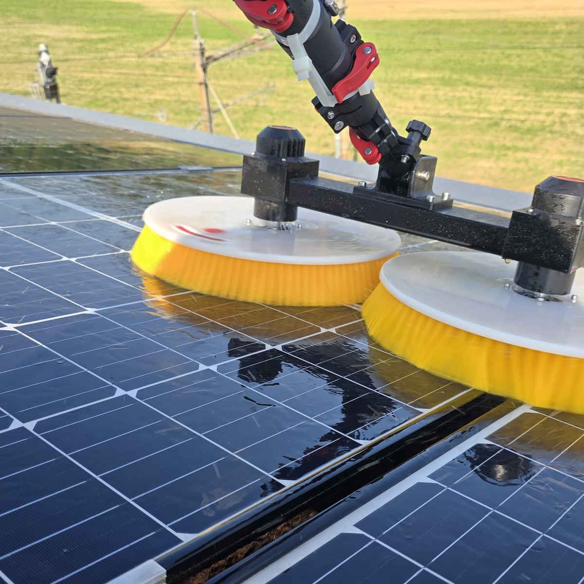 Rotierende gelbe Osmose-Bürsten reinigen die Solarmodule einer Photovoltaikanlage