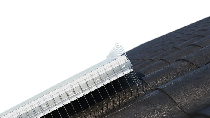 Spikes-Leiste entlang der Dachkante einer Solaranlage, von unten betrachtet
